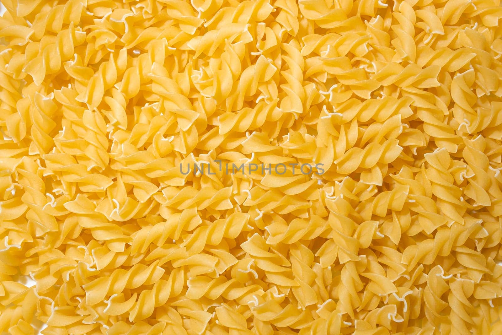 Uncooked Fusilli Pasta Background by InfinitumProdux