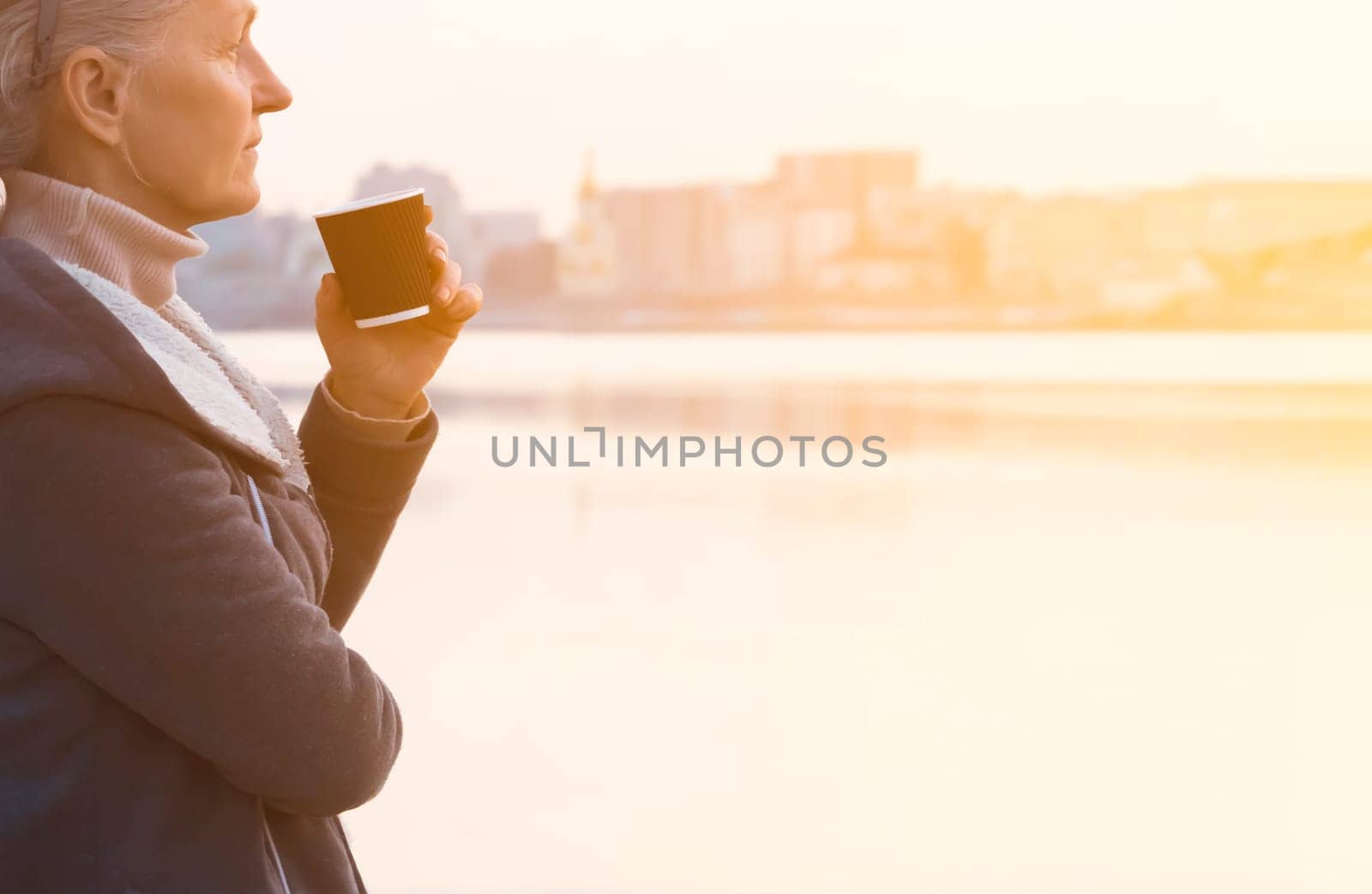 A woman, lady drinks a coffee and enjoys the sunset. by africapink