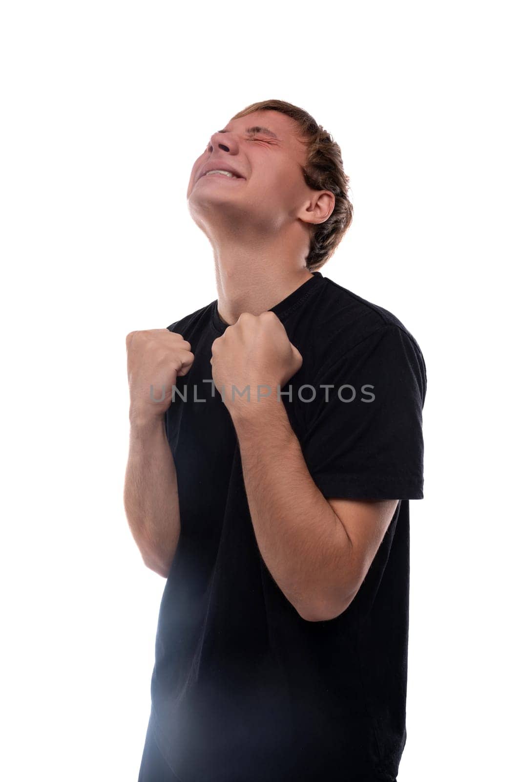 Cute teenage guy with blond hair dressed in a black T-shirt hoping for good luck.