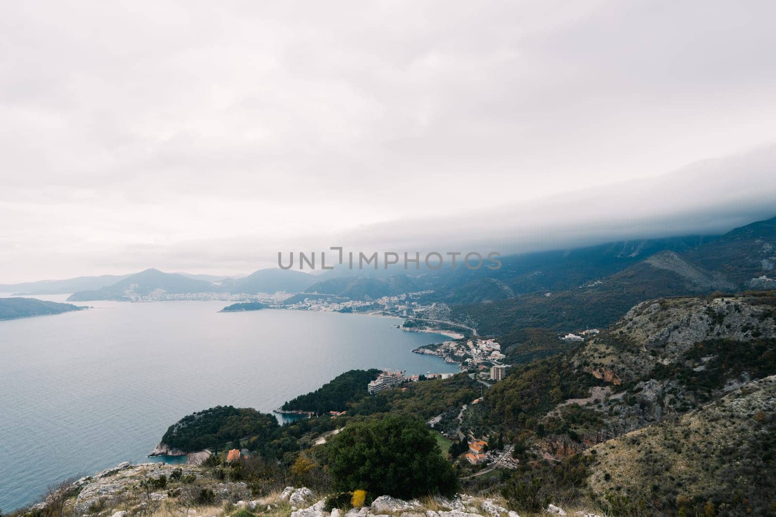 Bay surrounded by high green mountains in fog. High quality photo