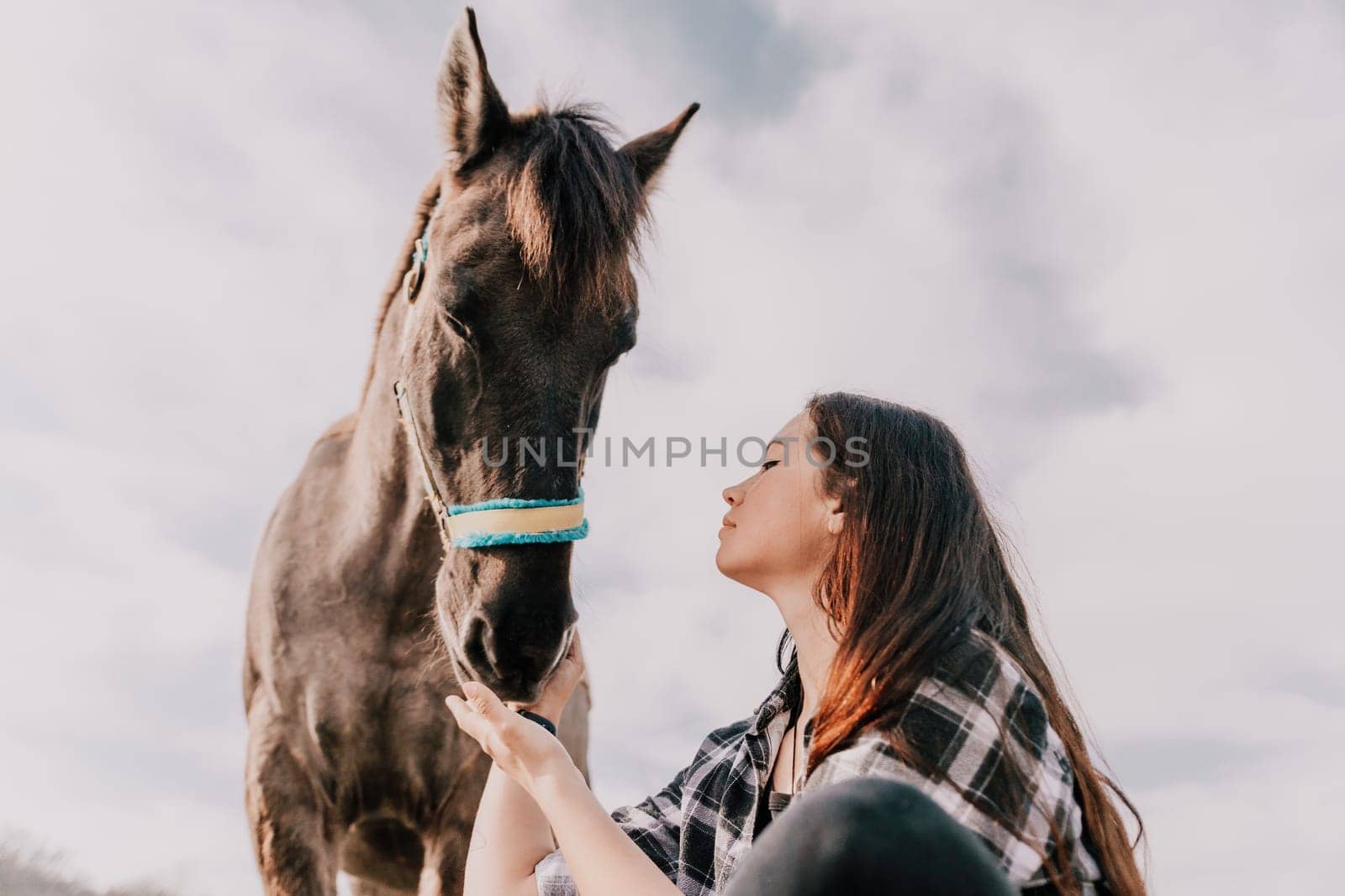 Young happy woman with her pony horse in evening sunset light. Outdoor photography with fashion model girl. Lifestyle mood. Concept of outdoor riding, sports and recreation. by panophotograph
