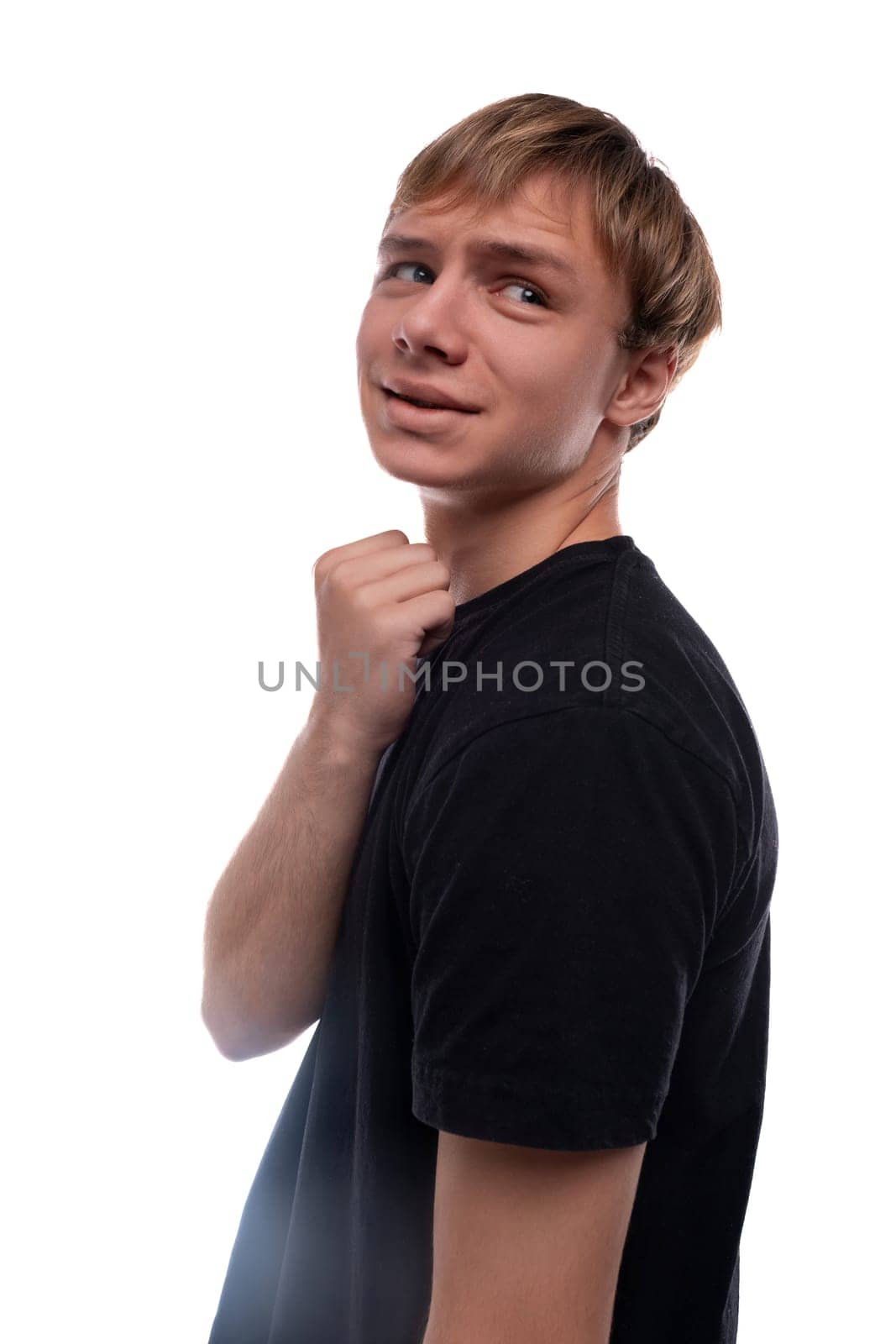 Blond teenager boy smiling on white background.