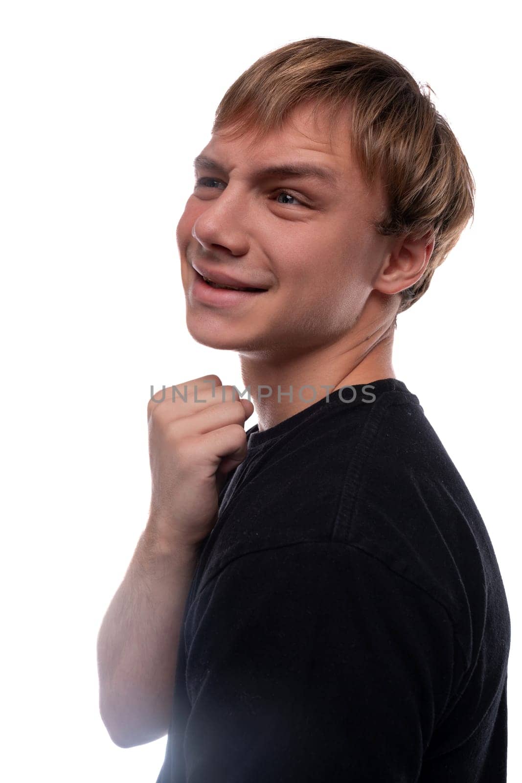 Satisfied European teenage guy with brown hair on a white background.