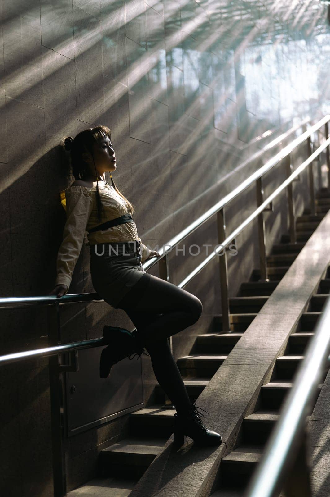 Portrait of a young Asian woman posing in the subway near the stairs. by mrwed54