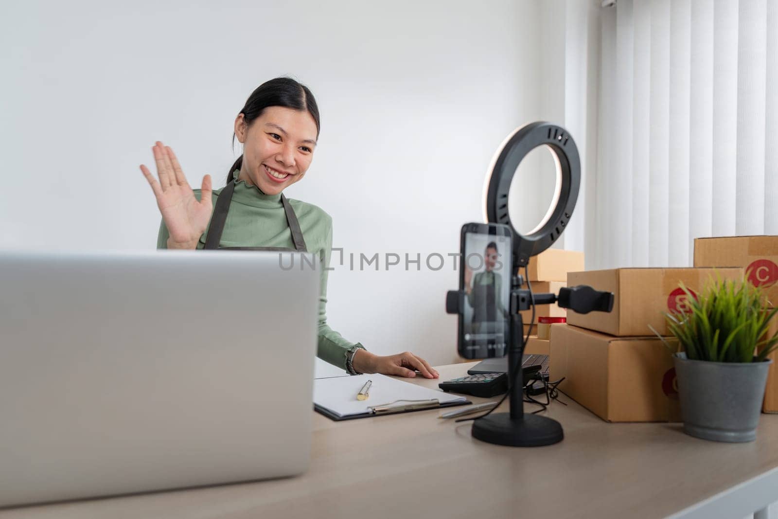 Beautiful asian woman blogger in front of camera to recording vlog video live streaming at her shop. Business online influencer on social media concept. Online Selling. Online Shopping.
