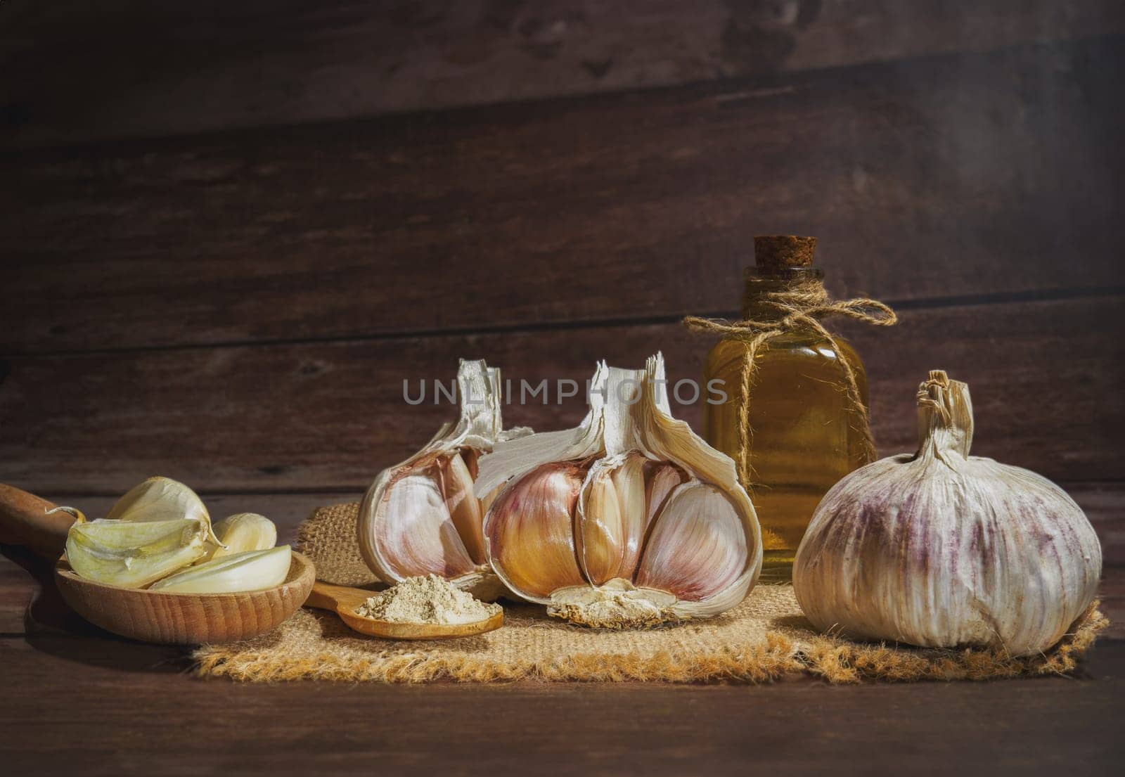 whole, powdered and chopped garlic on a burlap cloth by joseantona
