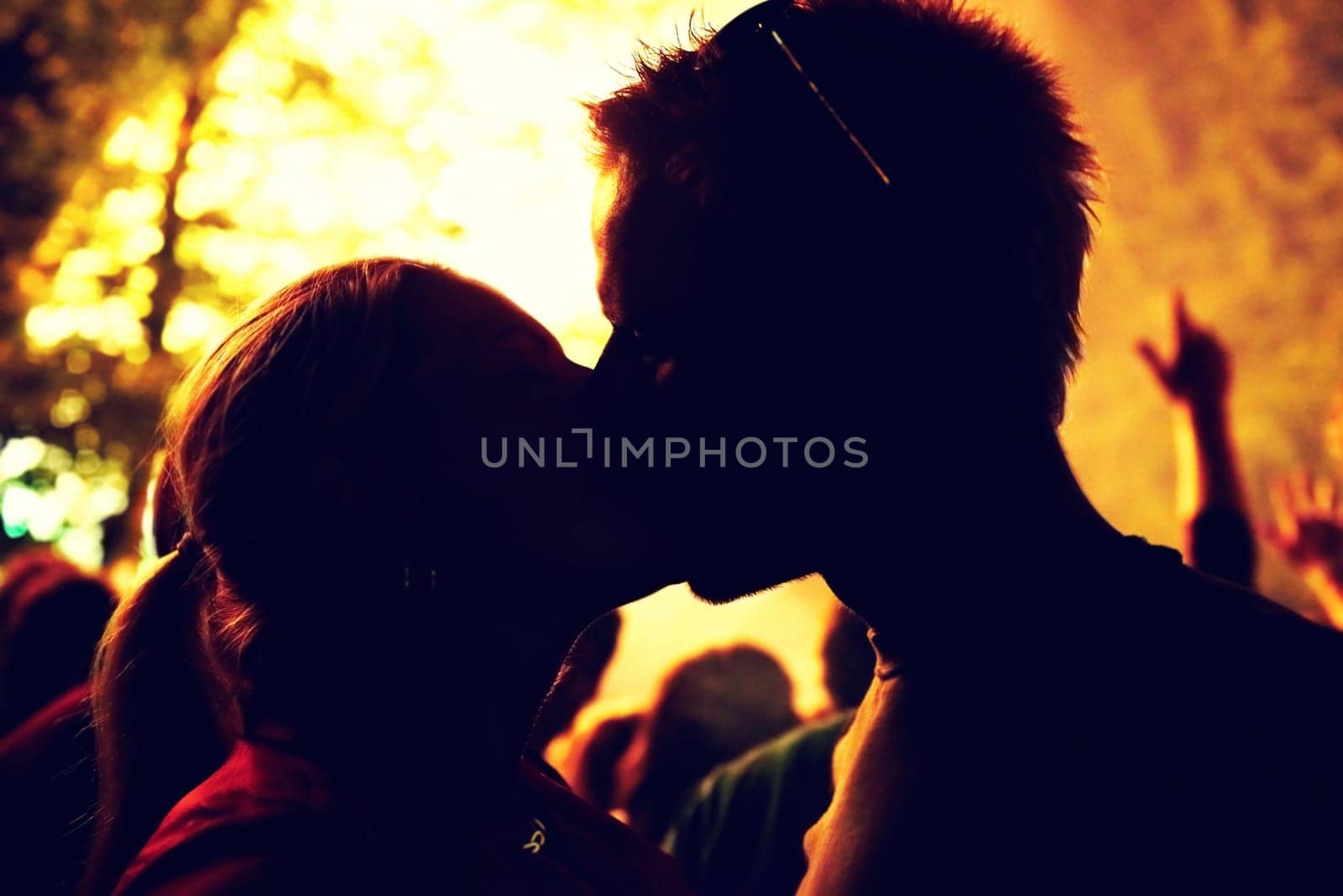 Outdoor, silhouette and couple with love, kiss and party with social event, romance and relationship. Romantic, man and woman with weekend break, fun and night with marriage, crowd and celebration by YuriArcurs