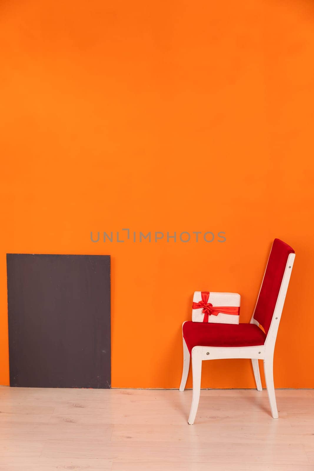 Chair With Holiday Gift Against Bright Colored Wall