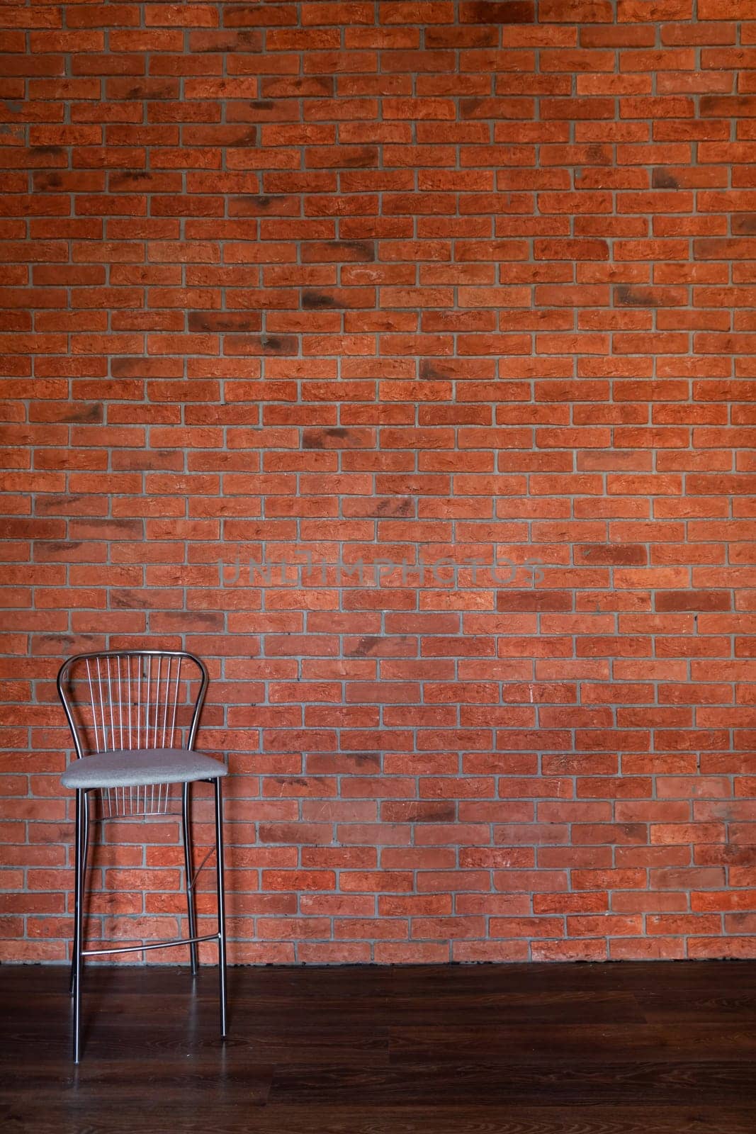 One vintage chair against an old brick wall in the interior by Simakov