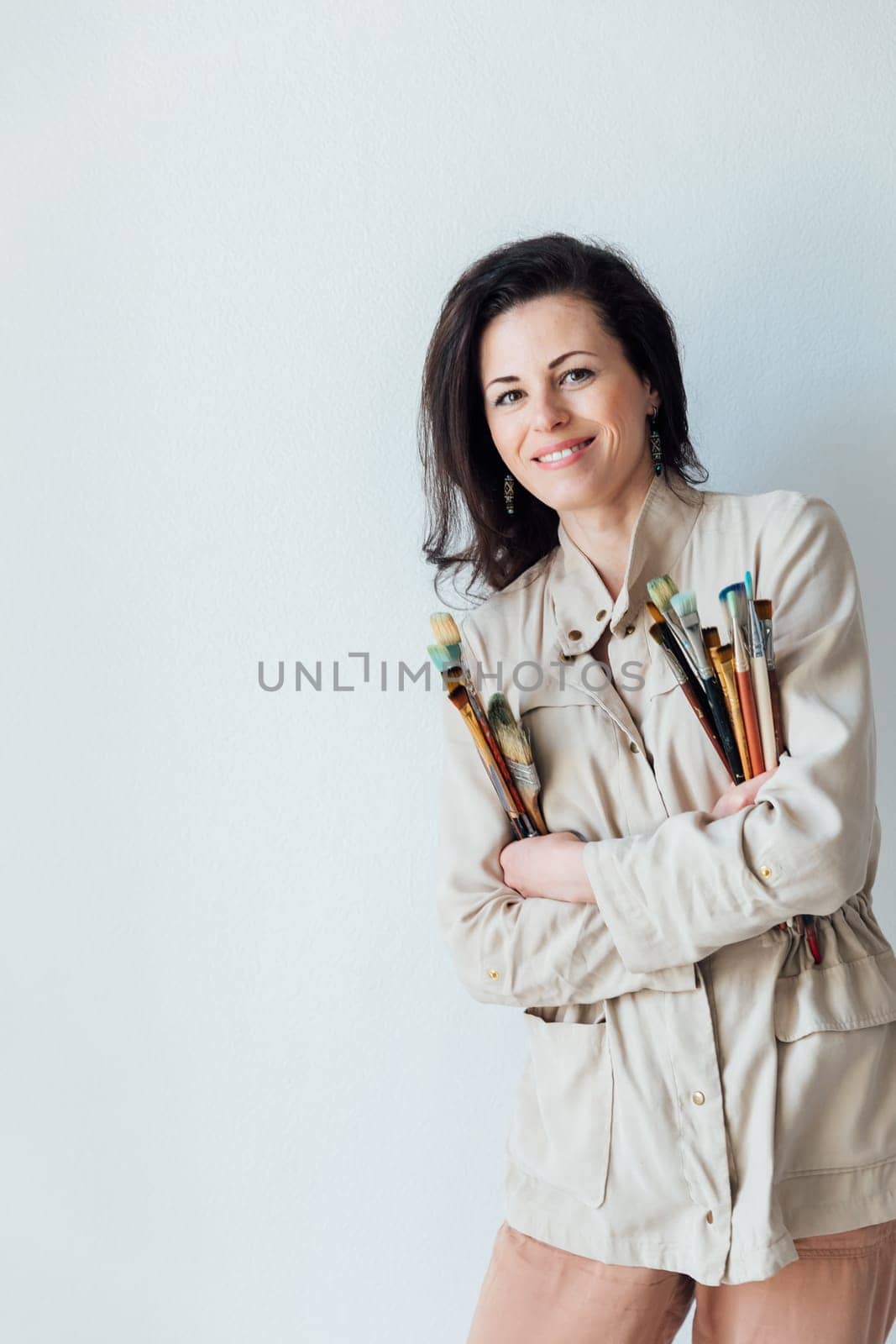 Brunette woman with art brushes on white background by Simakov