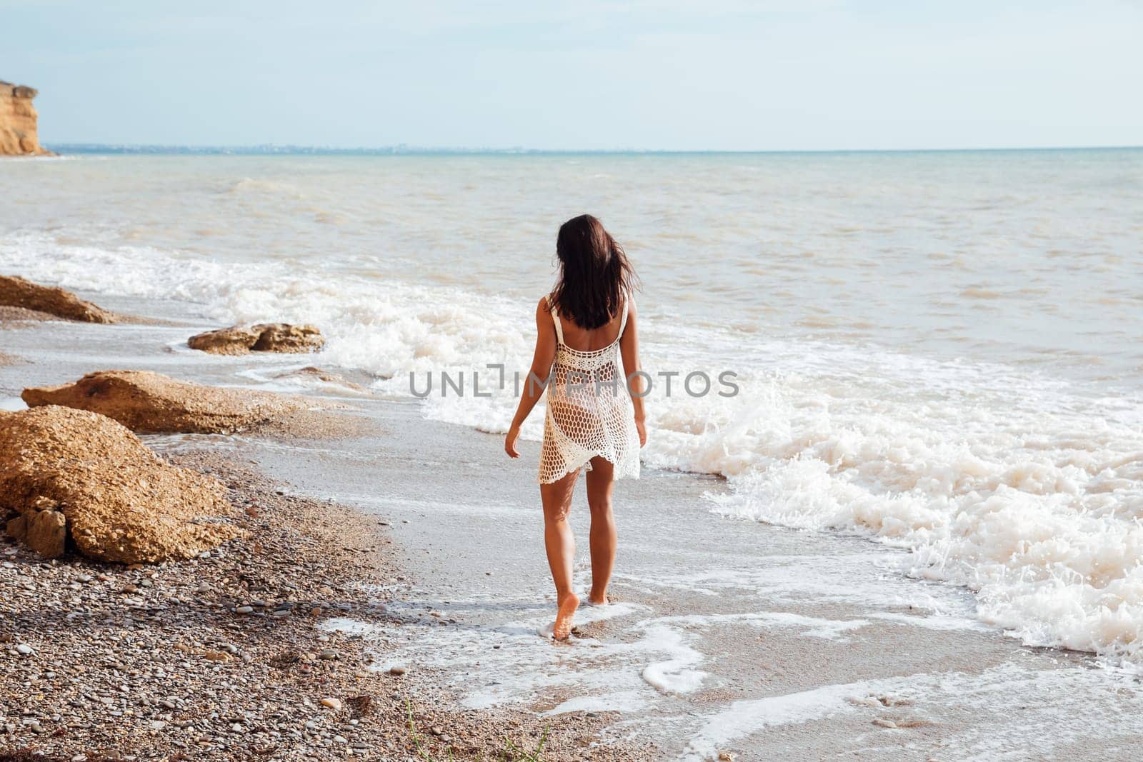 woman walking along the seashore on the beach walking travel vacation by Simakov