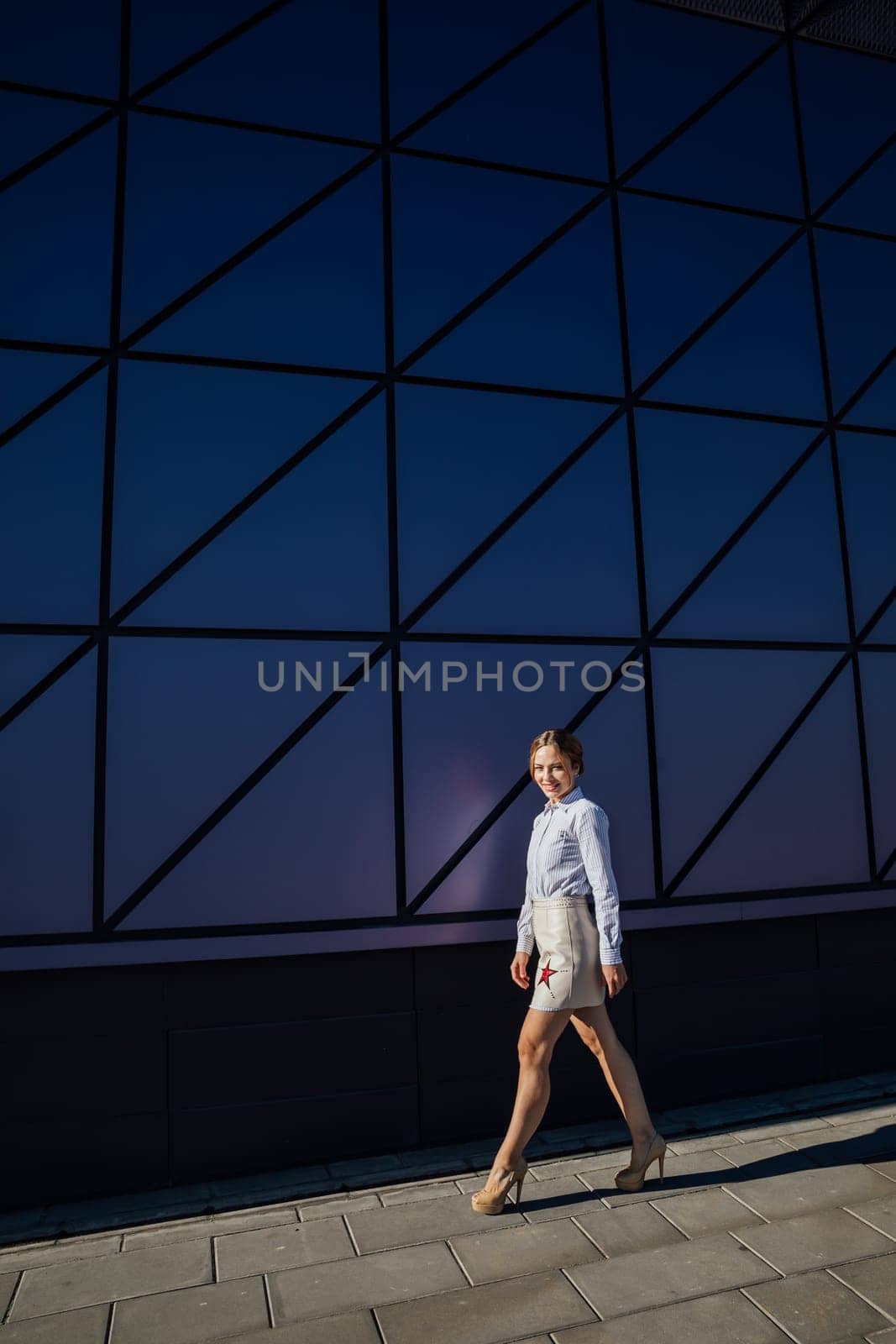 fashionable woman near glass wall showcase