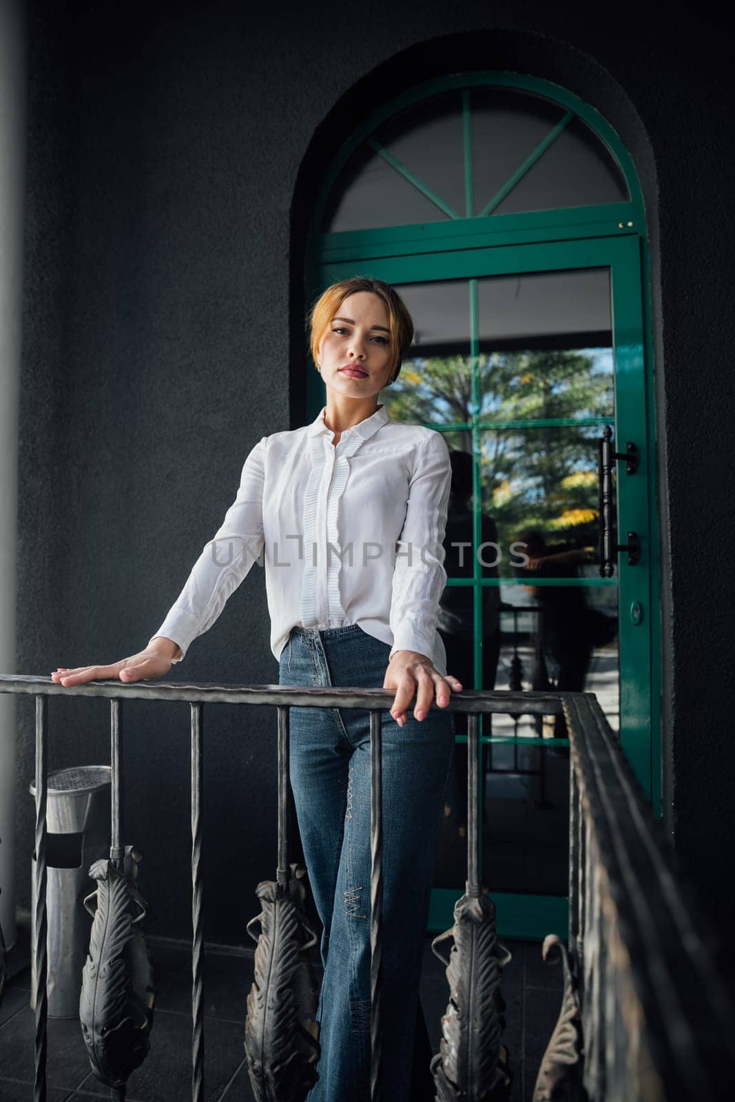 Beautiful fashionable woman near metal railing by Simakov