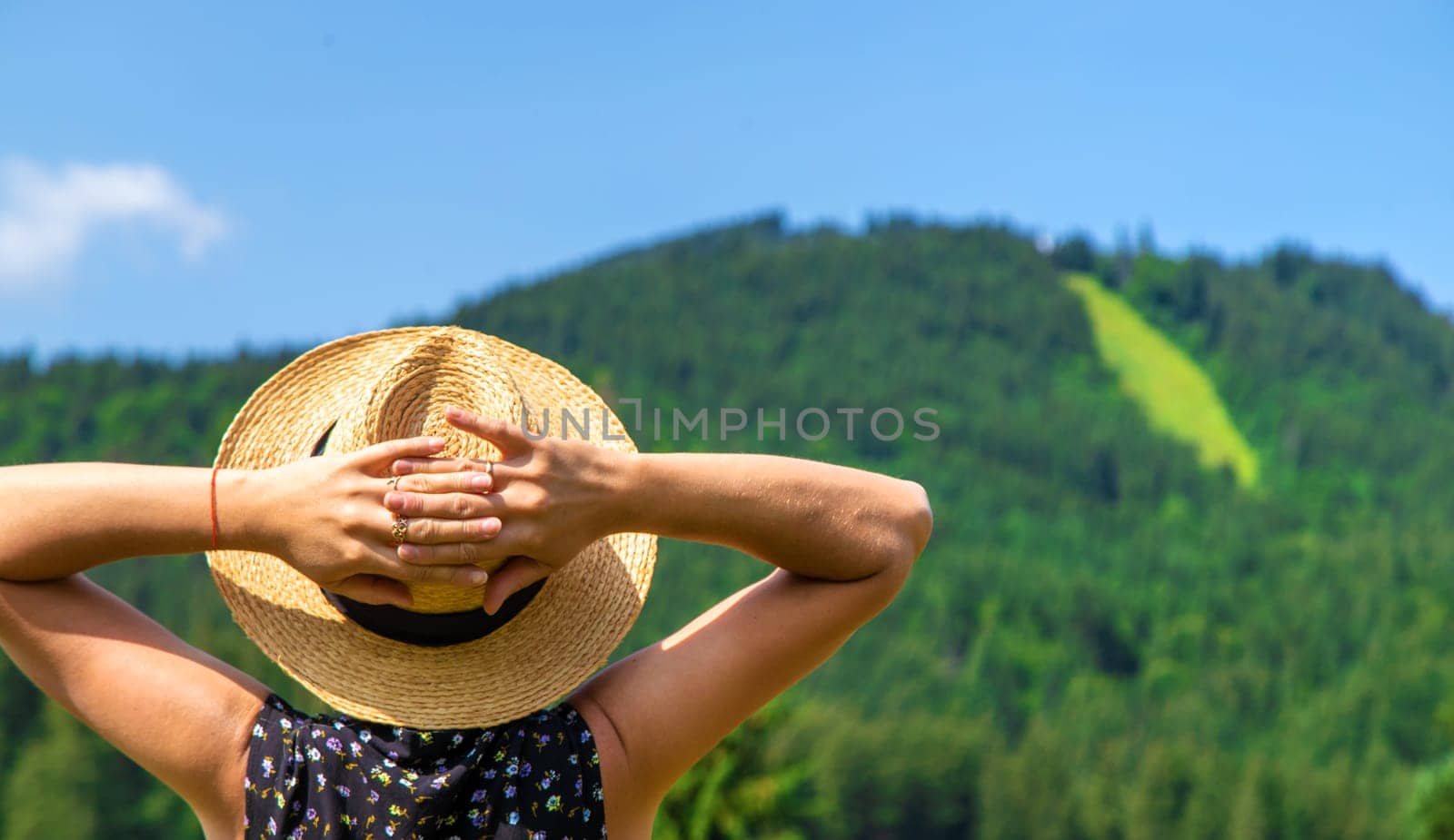 A woman in the mountains admires nature. Selective focus. Nature.