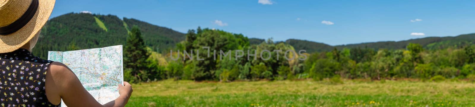 A woman in the mountains looks at a map. Selective focus. by yanadjana