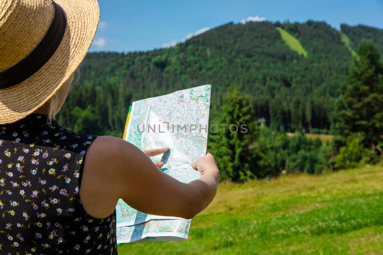 A woman in the mountains looks at a map. Selective focus. by yanadjana