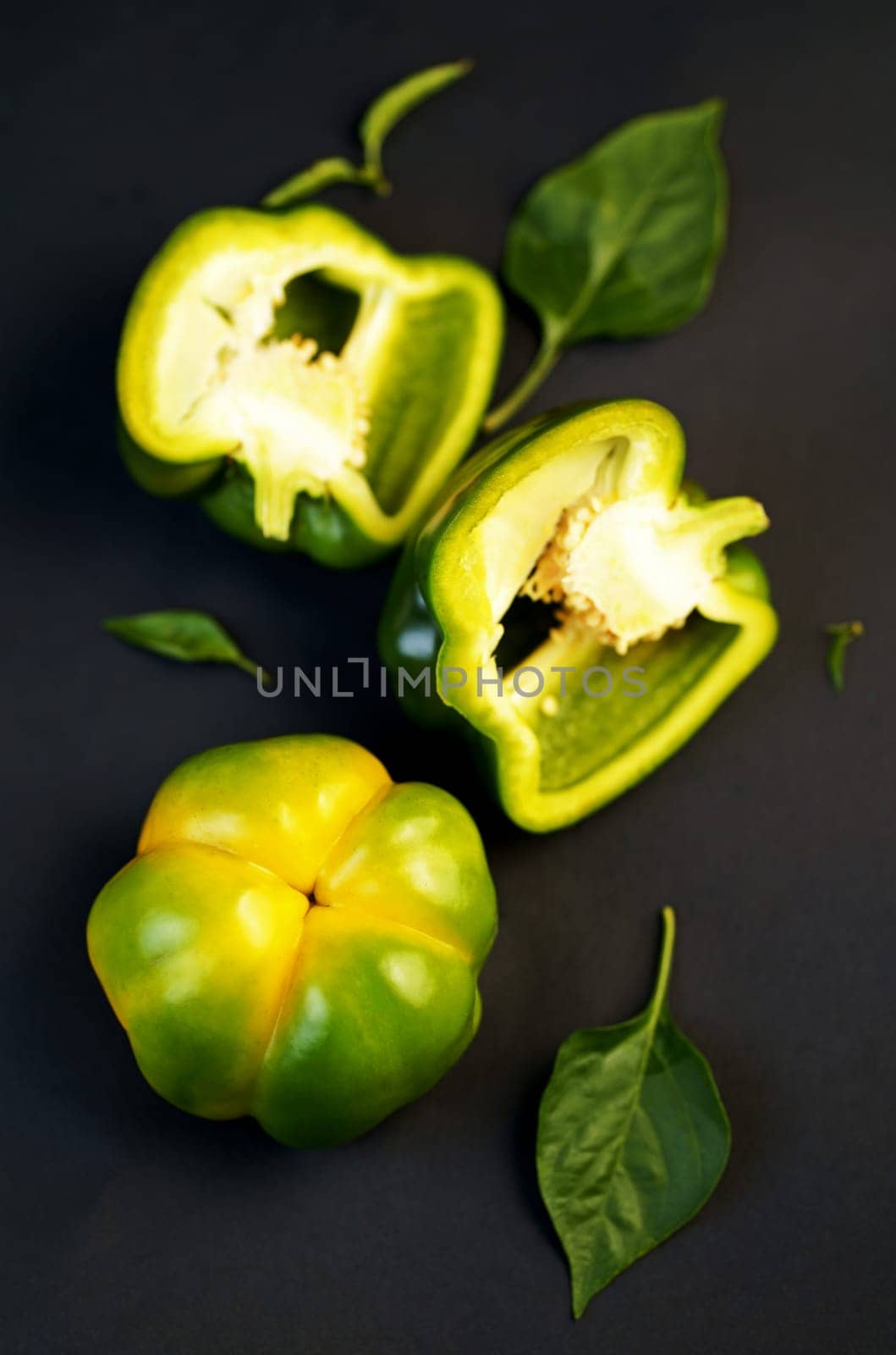 sweet green pepper, paprika, lies on a rough wooden board, dark background, full depth of field by aprilphoto