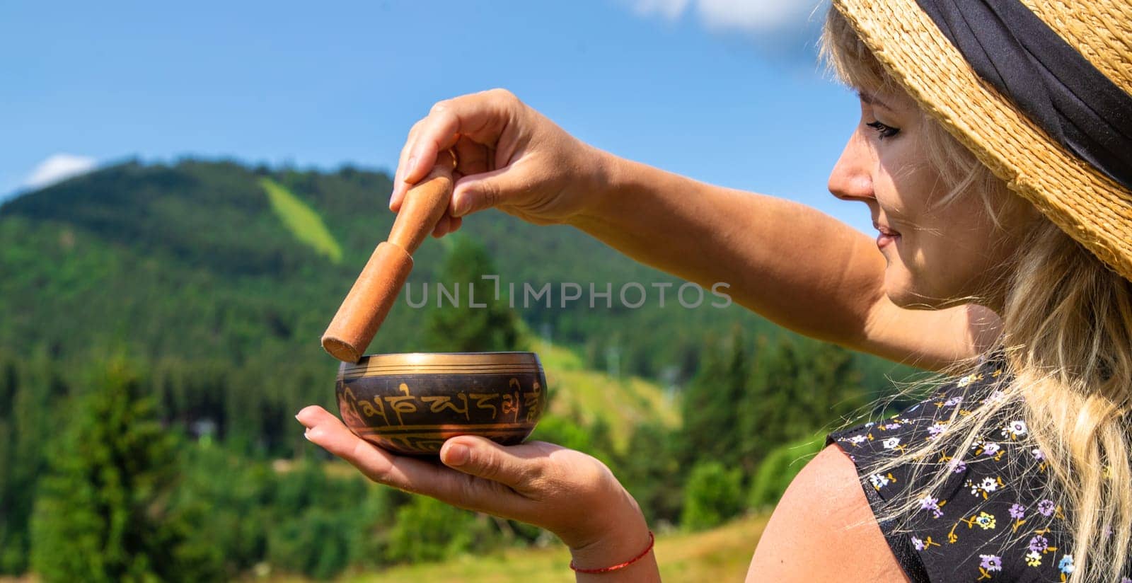 A woman holds a singing bowl in her hands. Selective focus. by yanadjana