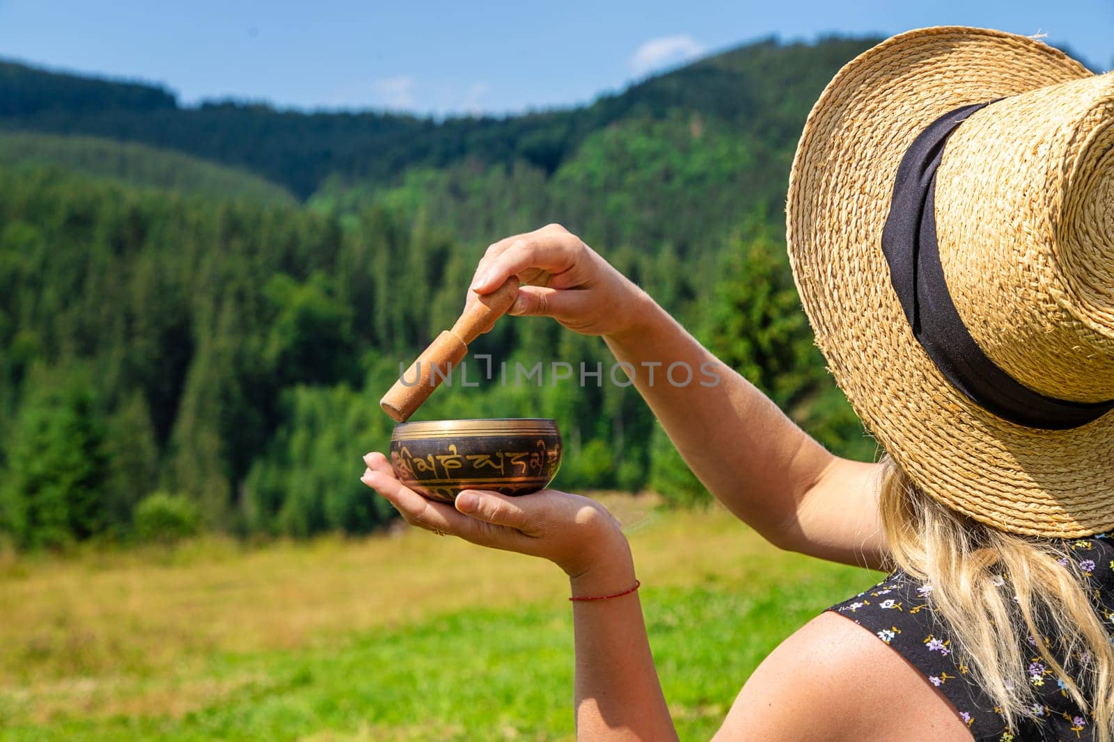 A woman holds a singing bowl in her hands. Selective focus. by yanadjana