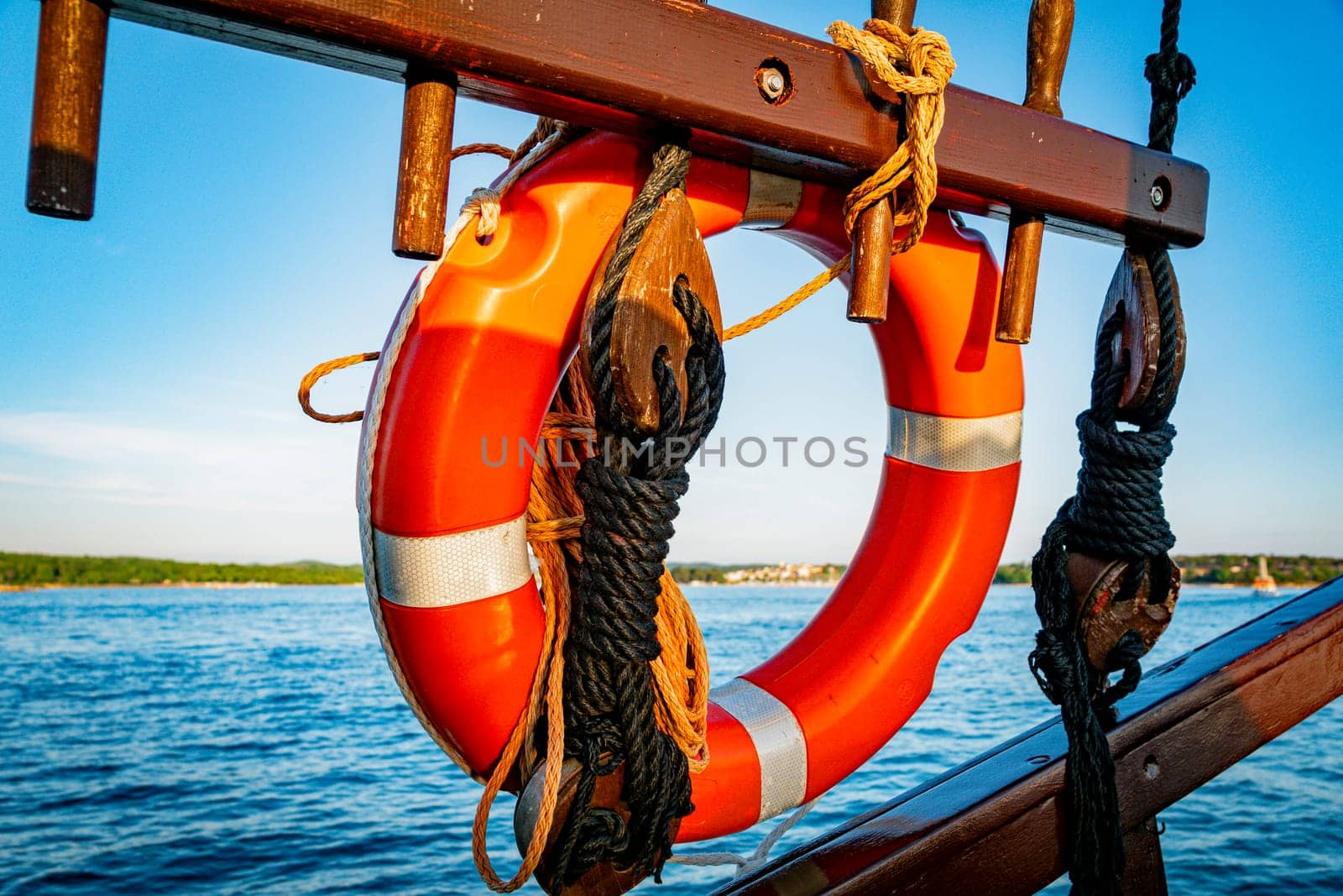 red lifebuoys on old brown wooden ship and a tropical island by compuinfoto