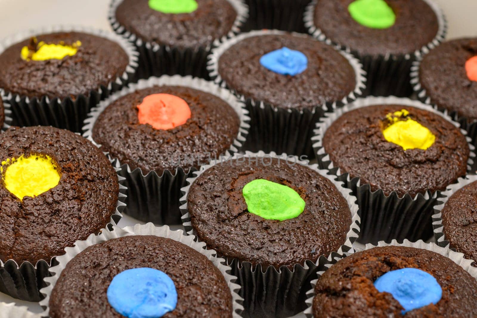 multi color muffins produce at professional catering baker in professional kitchen