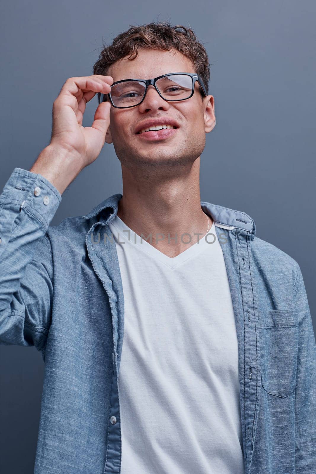 man wearing glasses on a gray background.