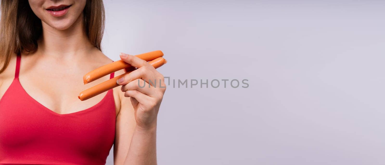 Woman opened her mouth and wants to bite off the sausage, close-up by Zelenin