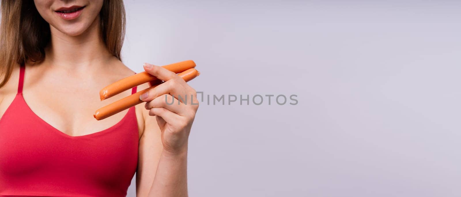 Woman opened her mouth and wants to bite off a sausage, close-up