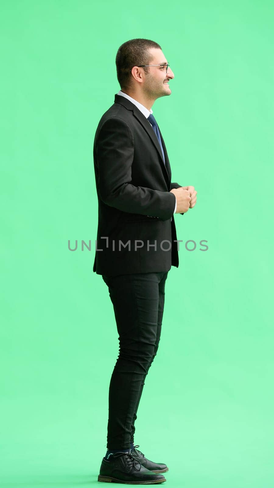 young man in full growth. isolated on green background profile.