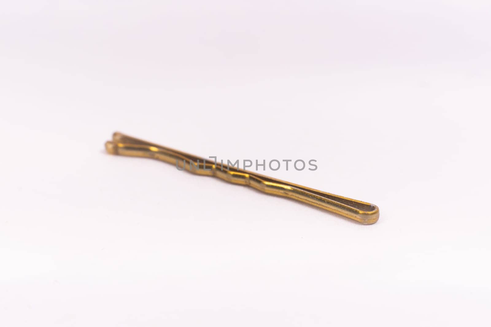 Small gold black metal hairpin isolated on a white background closeup