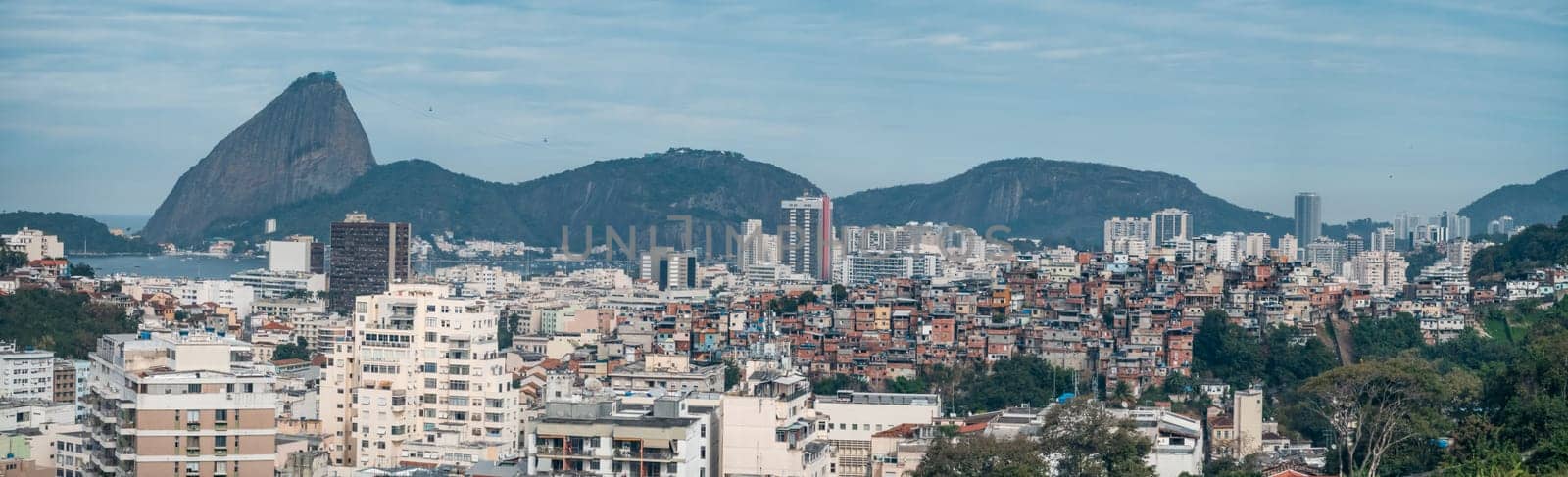 Rio's skyline blends modern structures and favelas against Sugarloaf Mountain's backdrop.