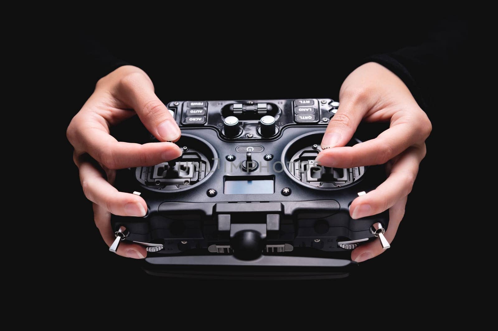 Remote control of FPV racing drone on black background in female hands, close-up by yanik88