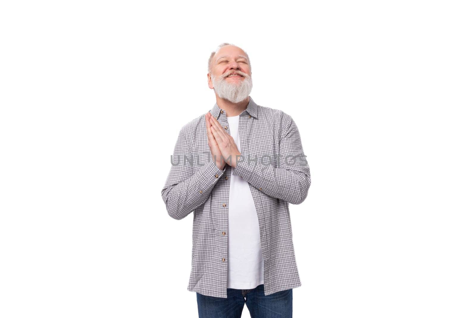 cute charming smart grandfather with a white beard and mustache is dressed in a striped shirt and jeans.