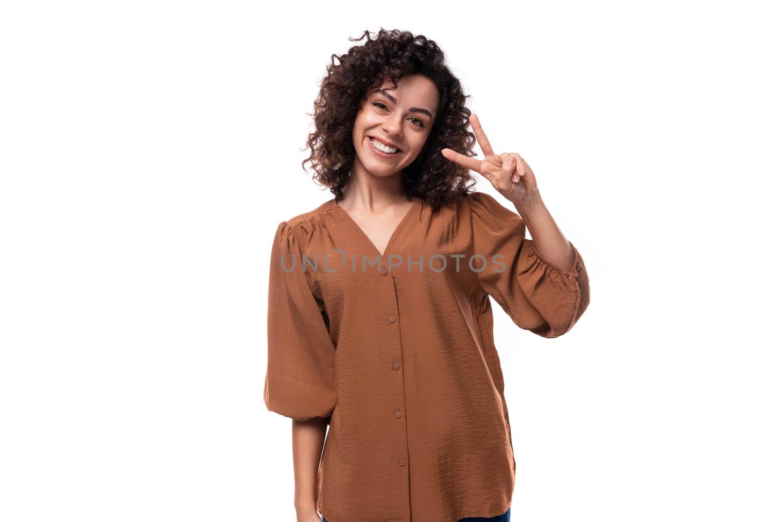 young curly leader woman in a brown blouse covered her mouth with her hand in surprise.