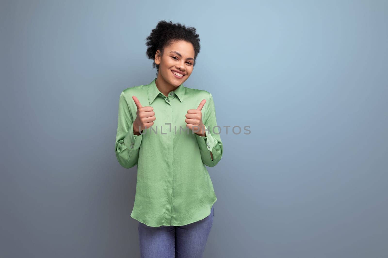 young positive latin woman dressed in a green shirt smiling on the background with copy space by TRMK