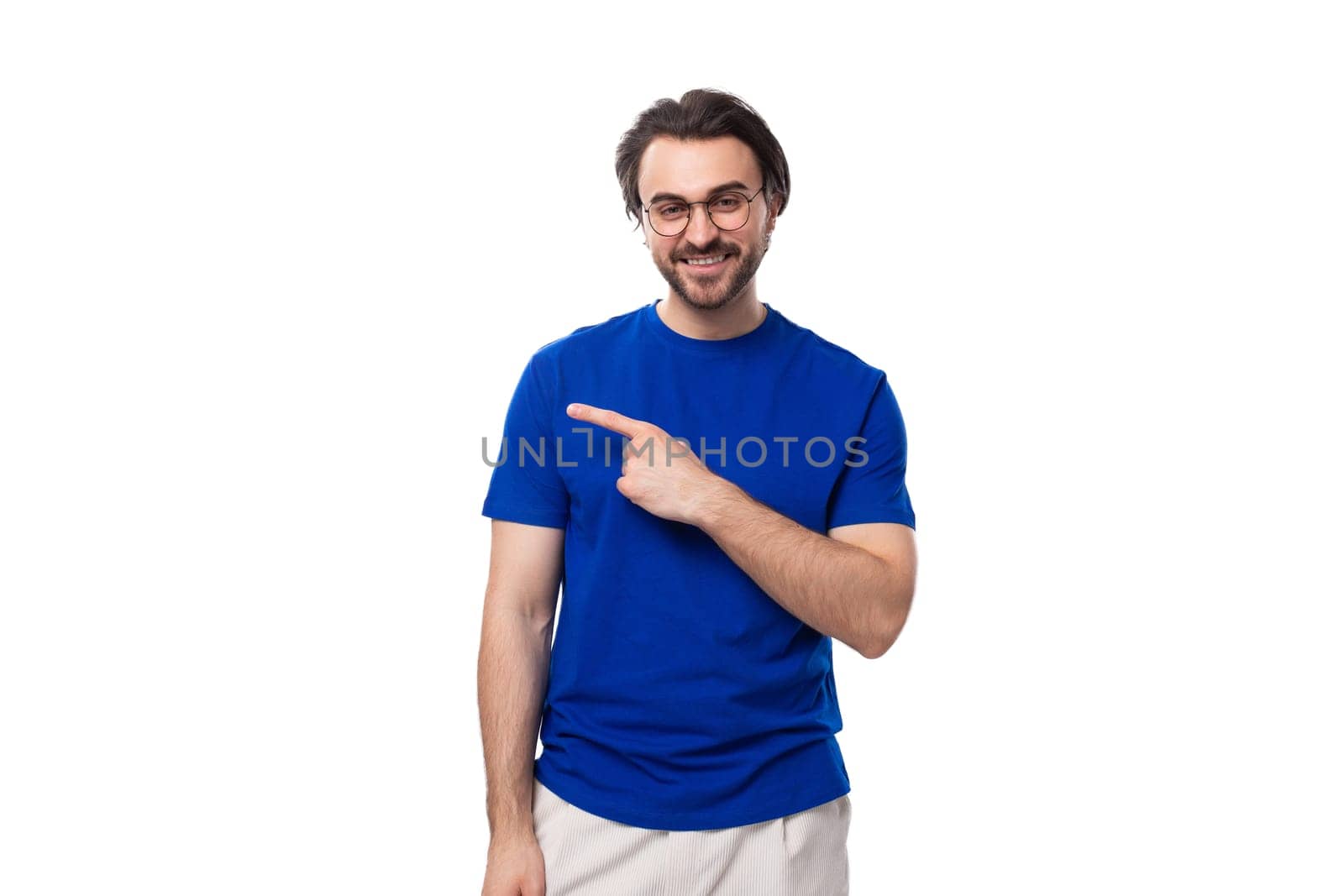 caucasian man with dark well-groomed hair and a beard in a blue t-shirt points his hand to the side by TRMK