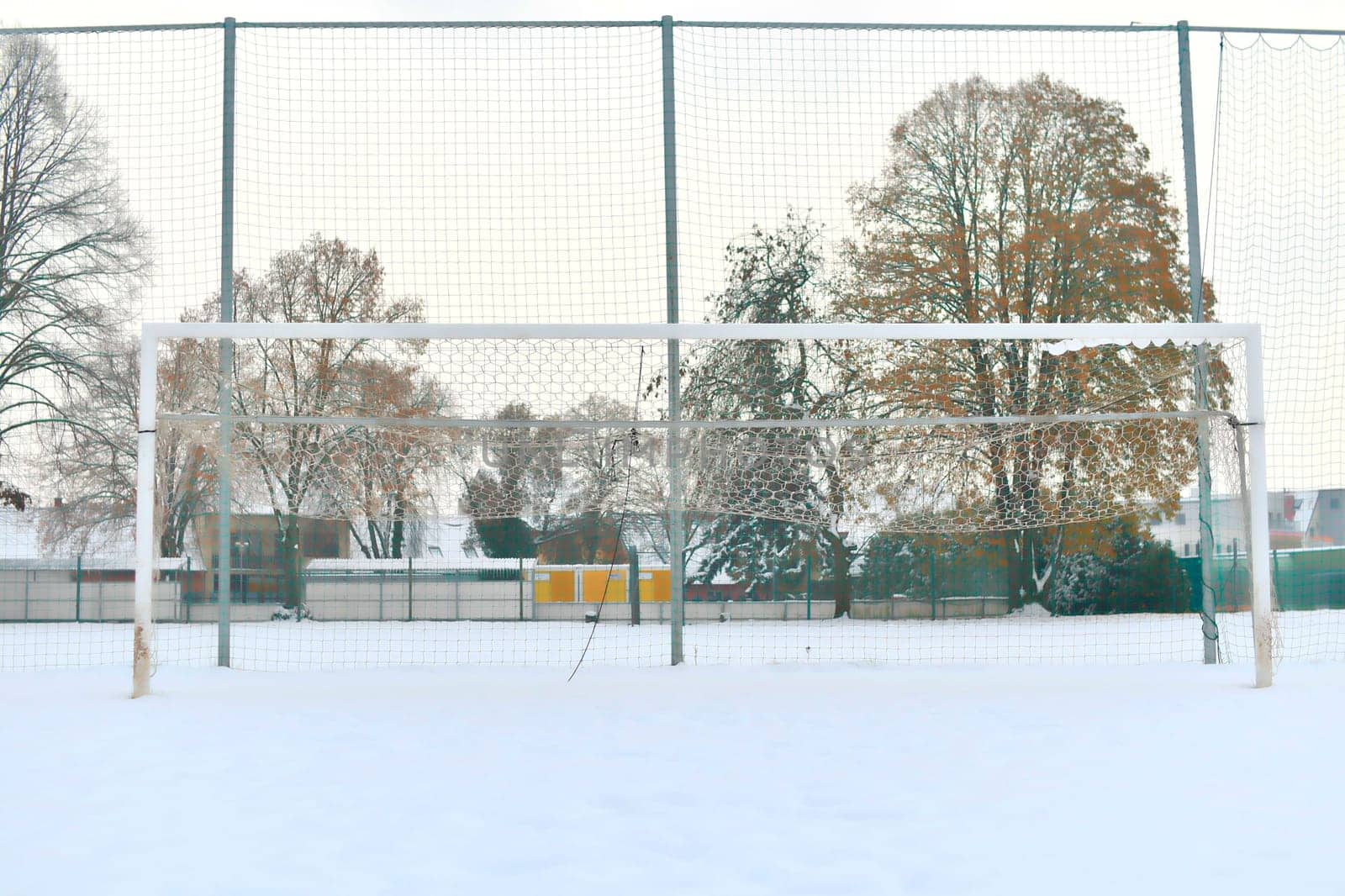 A snow-covered football goal. The concept of the end of the football season, the football league and the end of the sports season.