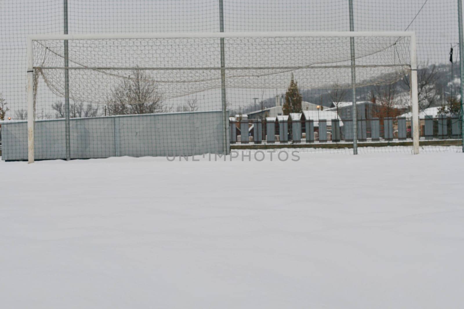 A football goal covered in snow. The concept of the end of the football season and the end of the football league.