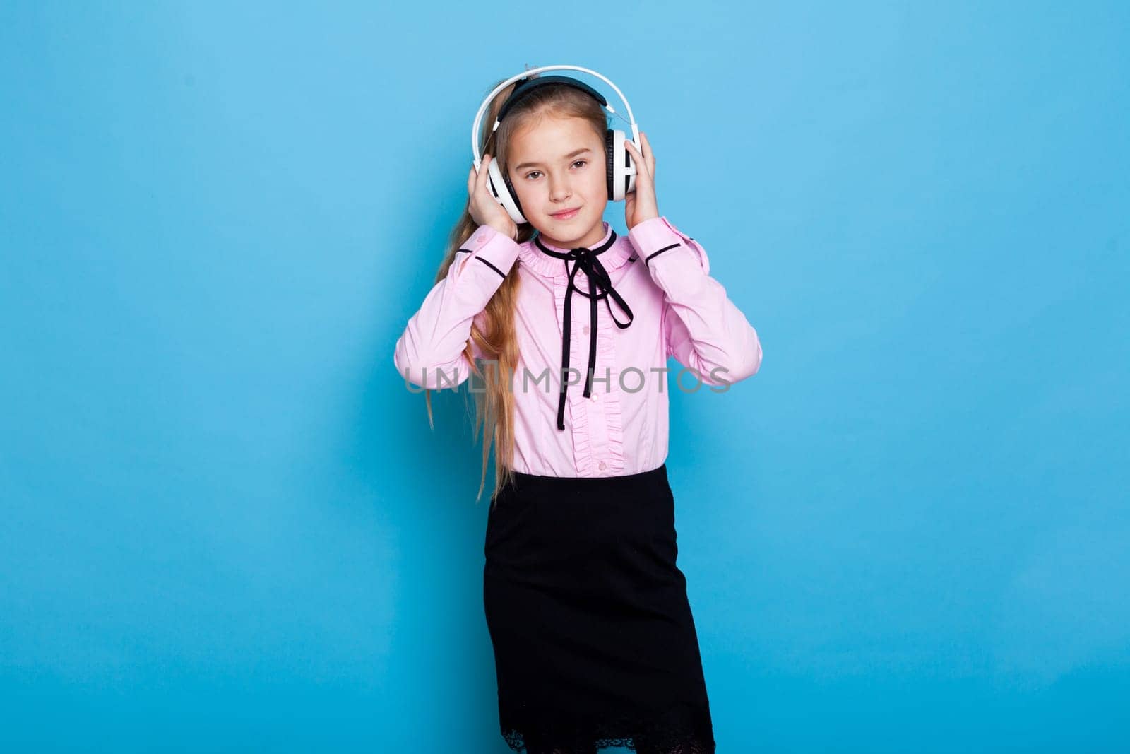 Beautiful girl listens to dance music in big headphones by Simakov