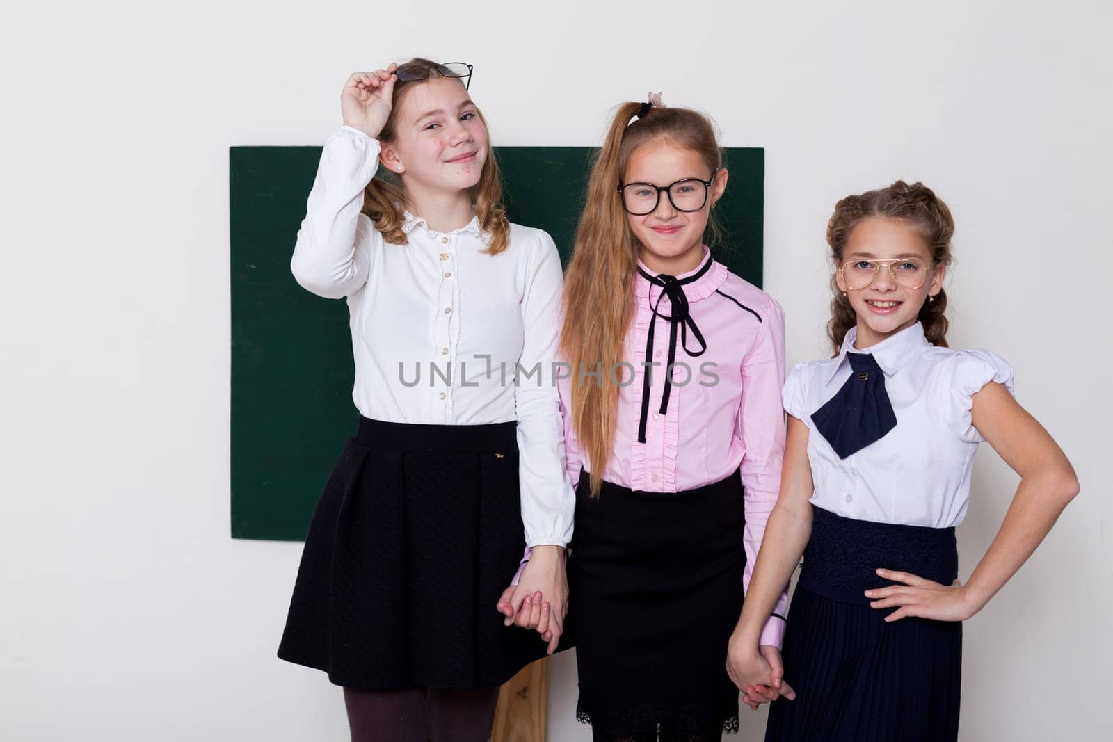 three girls schoolgirl girlfriend in class at the green board