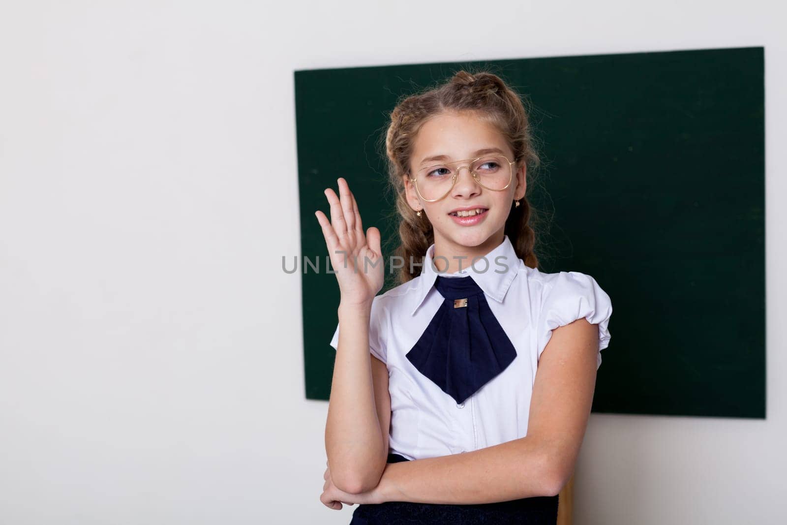 girl with glasses in class by green board