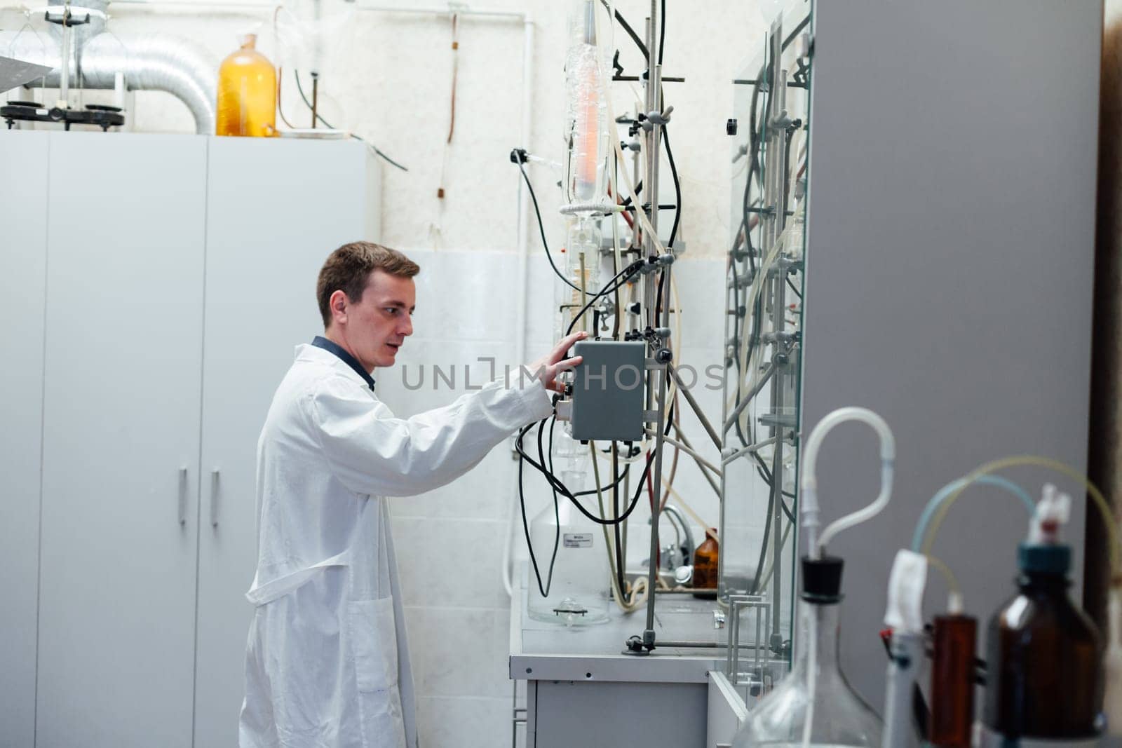 male scientist conducts chemical experiments in medical science laboratory by Simakov