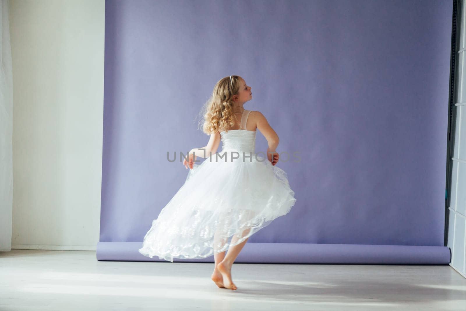 Beautiful girl of 10 years dancing alone in a white dress