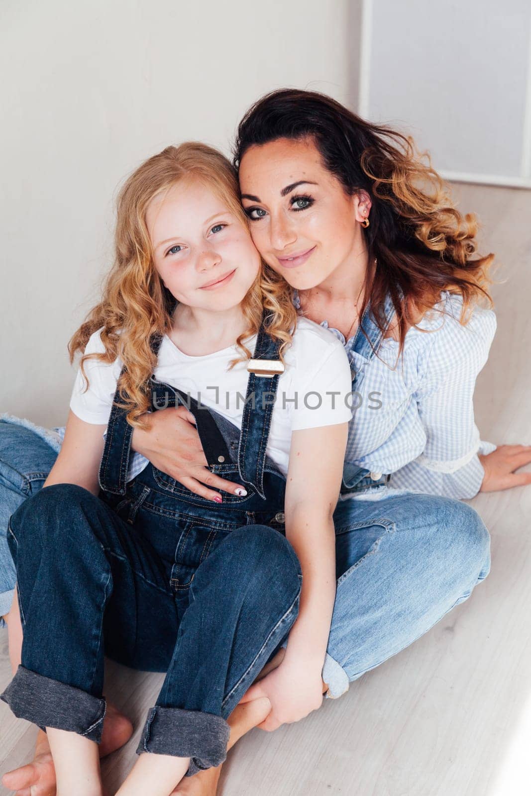 Portrait of a beautiful fashionable mom and daughter's family love by Simakov