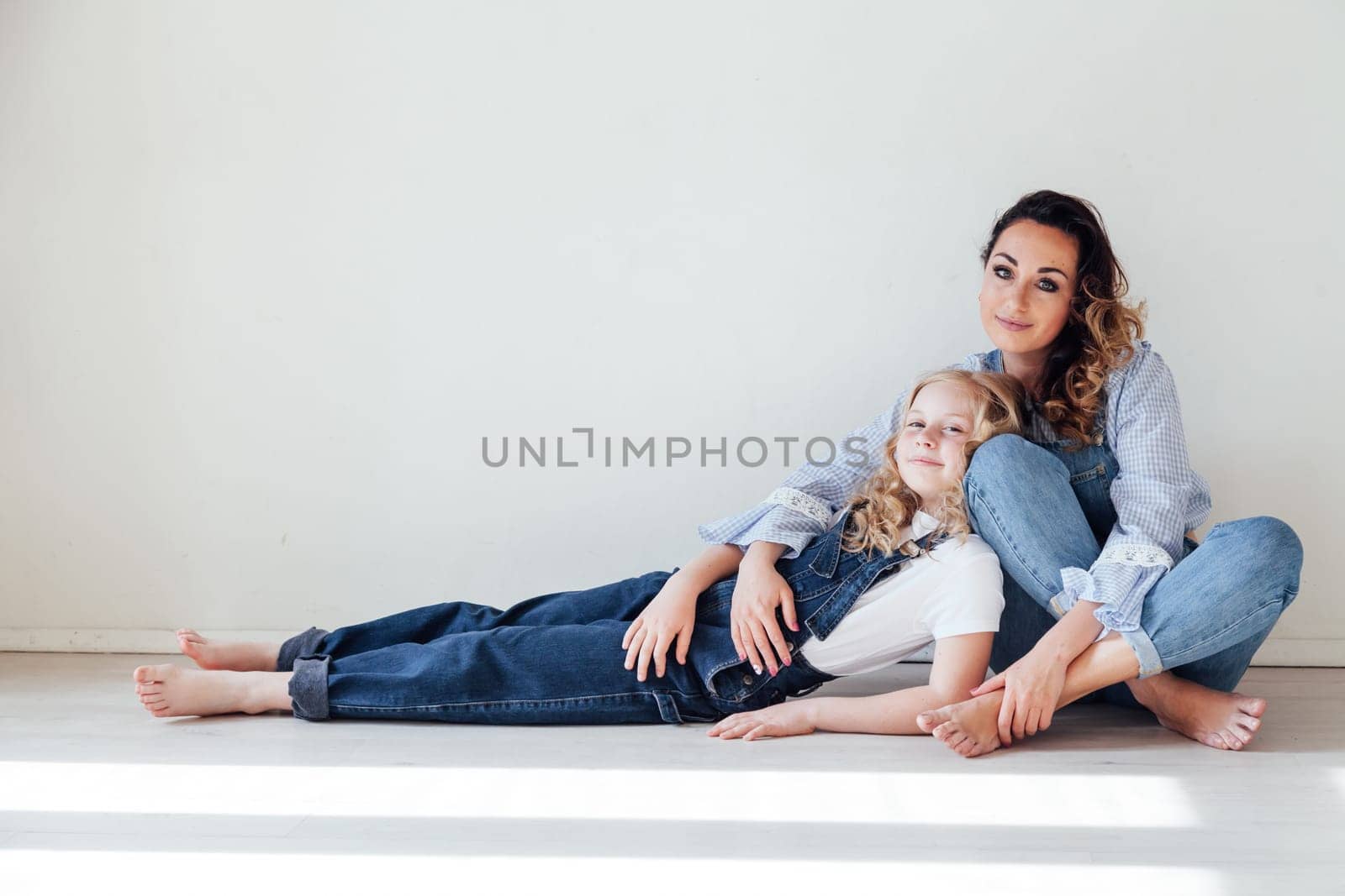 Portrait of a beautiful fashionable mom and daughter's family love by Simakov
