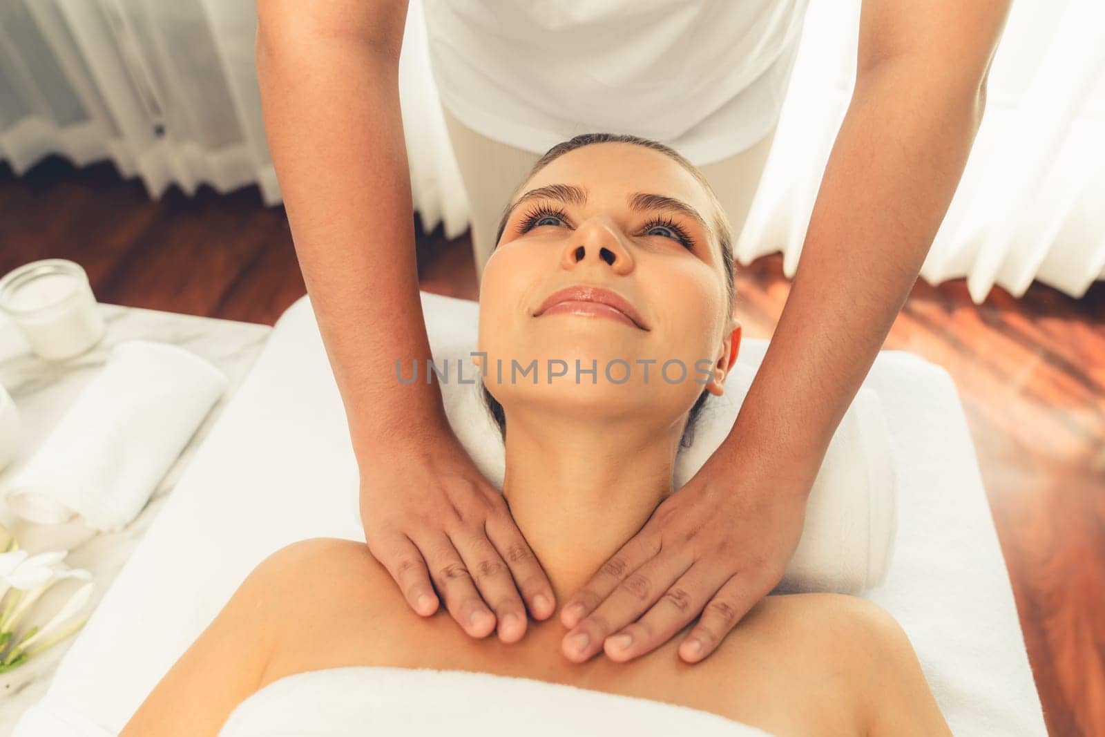 Caucasian woman customer enjoying relaxing anti-stress spa massage and pampering with beauty skin recreation leisure in day light ambient salon spa at luxury resort or hotel. Quiescent