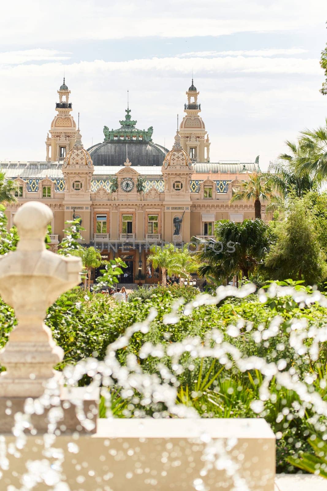 Monaco, Monte-Carlo, 21 October 2022 - Square Casino Monte-Carlo at sunny day, wealth life, tourists take pictures of the landmark, pine trees, blue sky. High quality photo