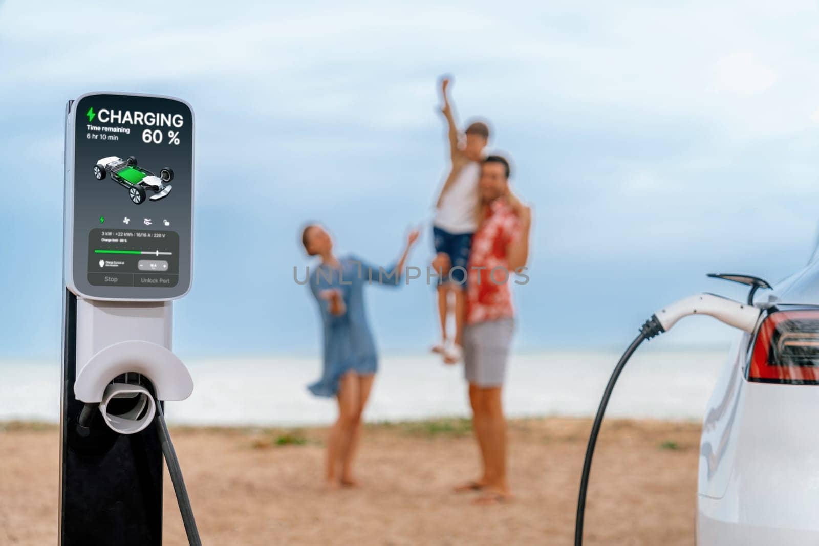 EV car charging with blurred cheerful family on the beach. Perpetual by biancoblue