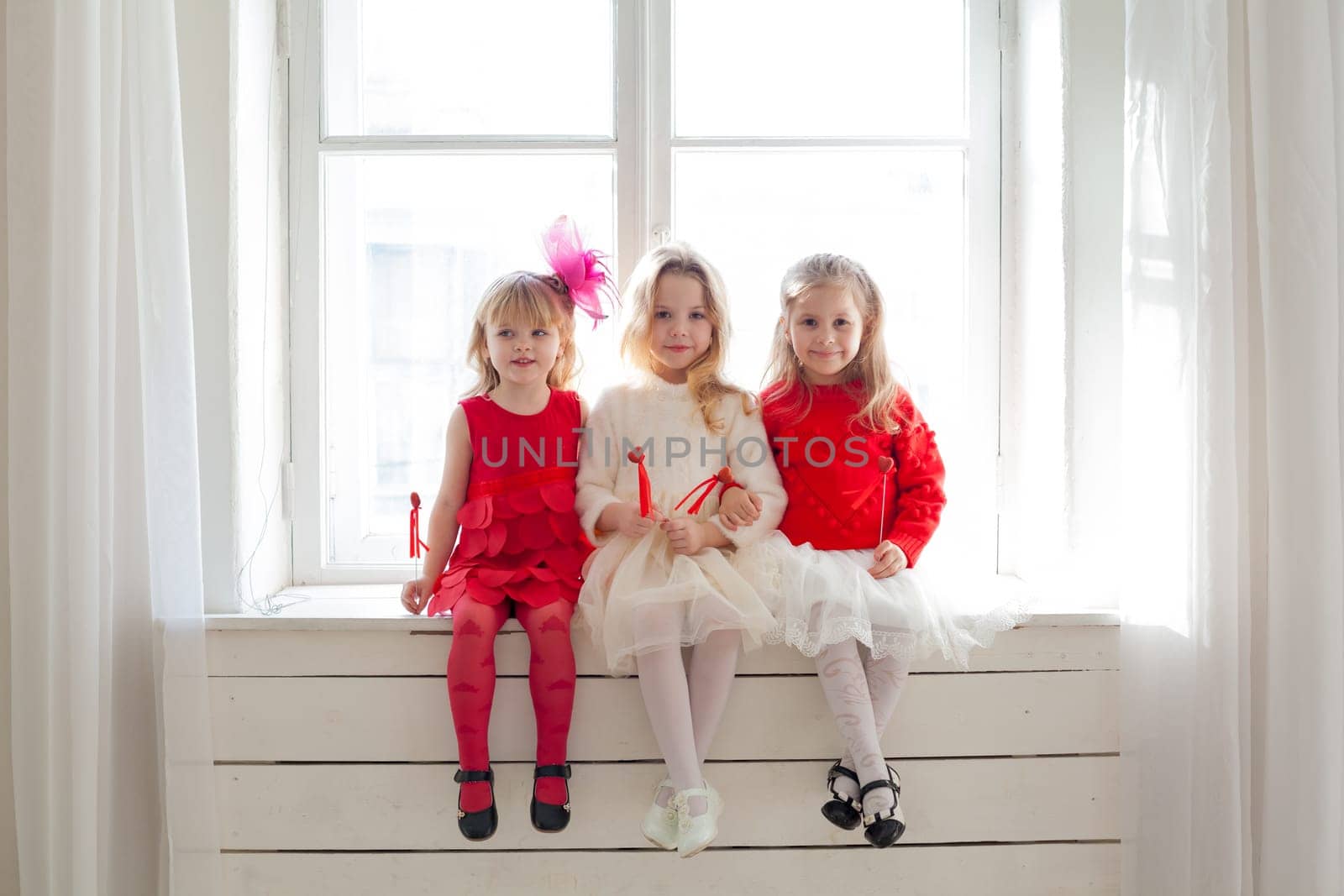 three little girls in red and white dresses at the party