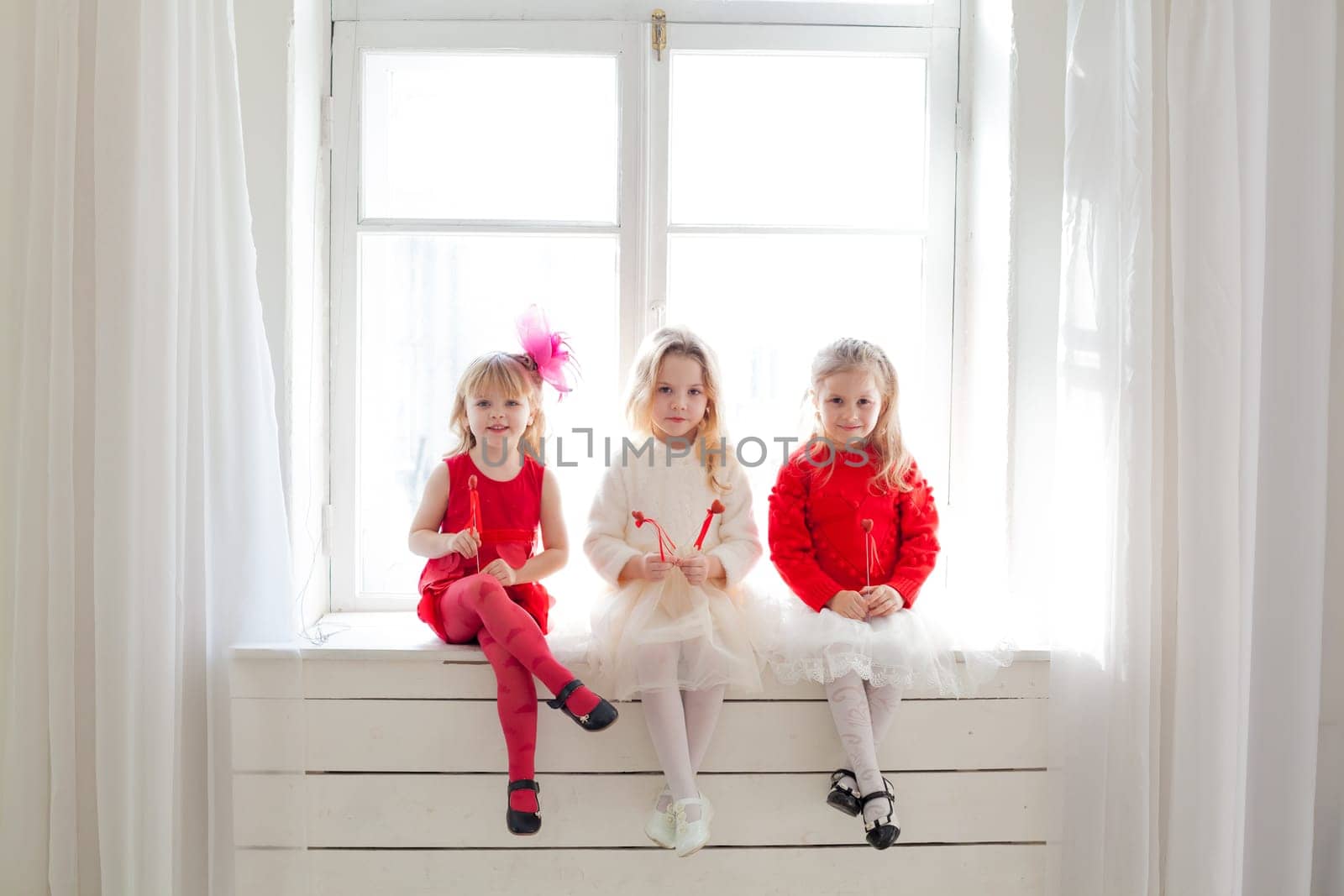 three little girls in red and white dresses at the party